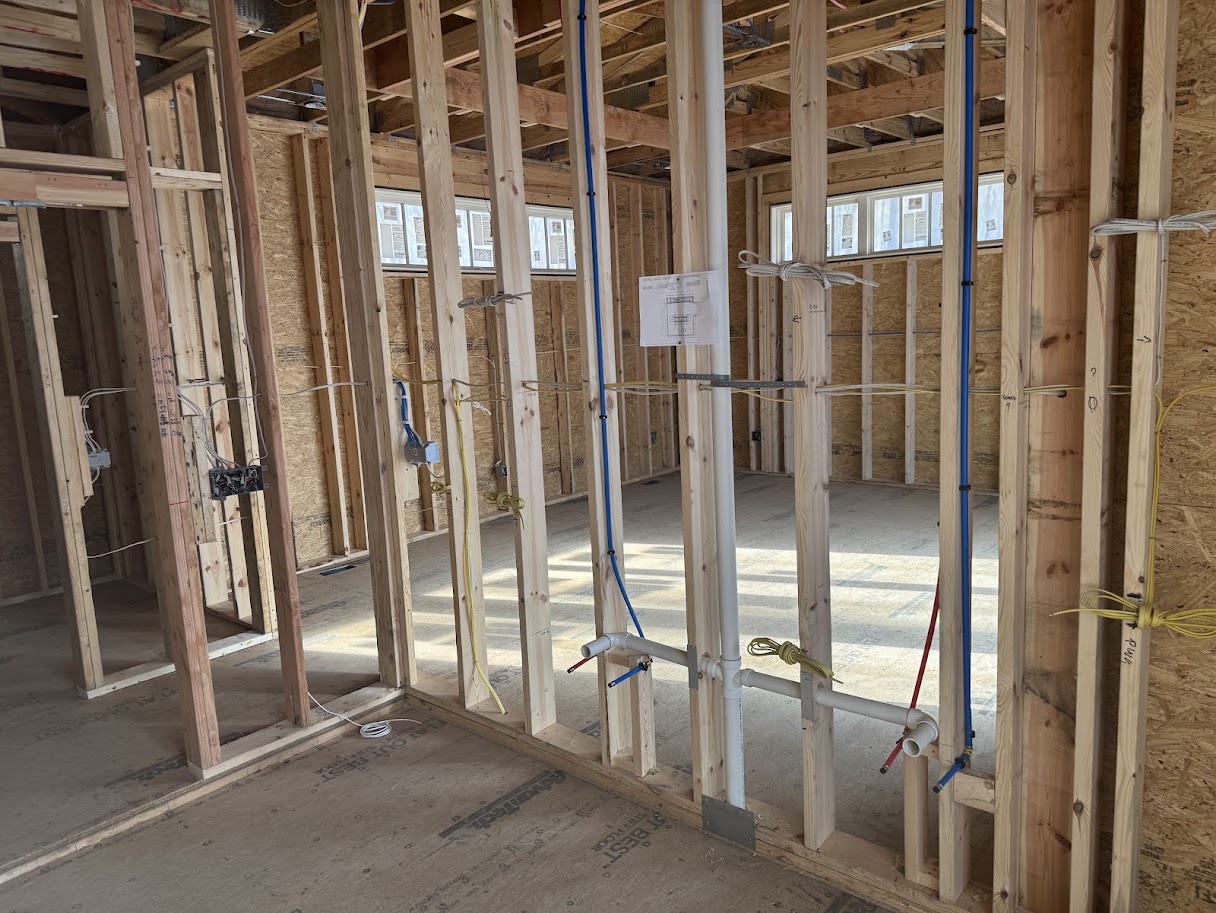 Building plans displayed within framed construction during preconstruction planning